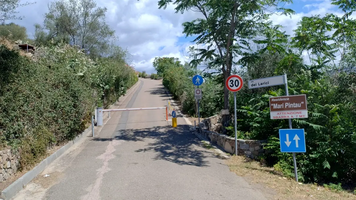 The slightly uphill road with the entrance bar and the Residence Mari Pintau sign.