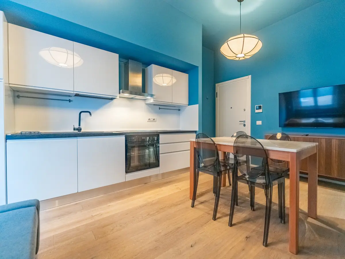 White kitchen with oven, dining table and clear chairs